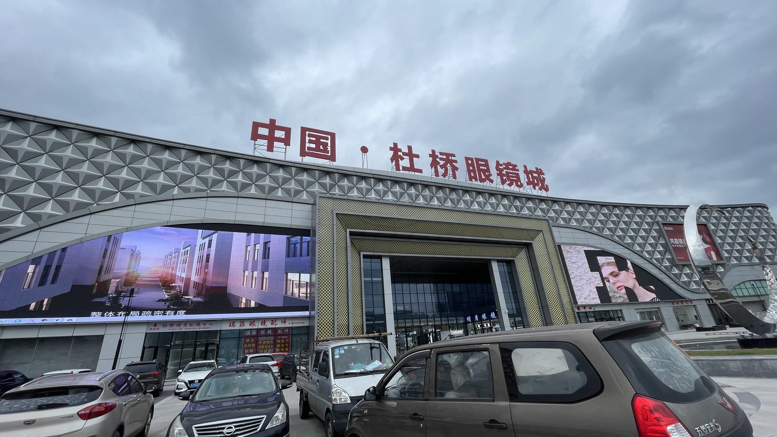 Entrance of China Duqiao Glasses City, with the building name above the doors and shopfronts along the ground floor.