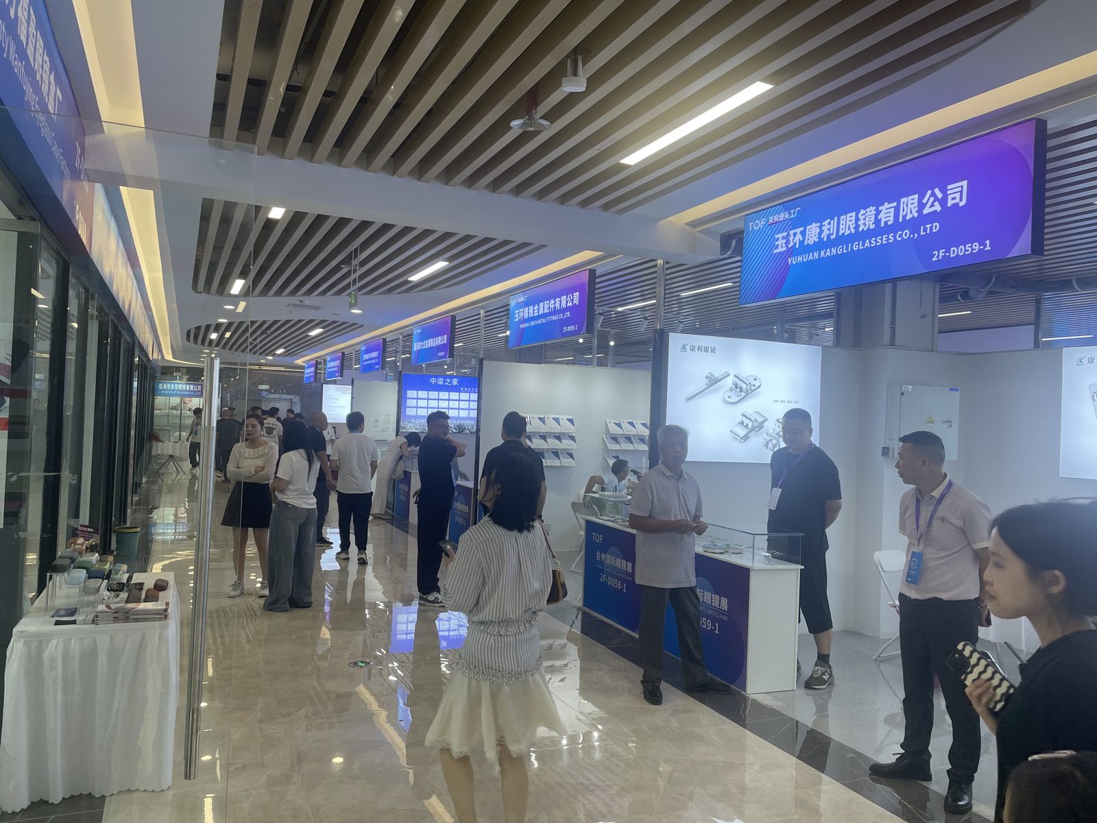 Second-floor corridor during a previous Taizhou Optical Fair, with glass-fronted booths and component displays.